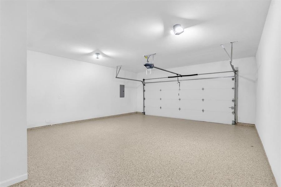 Garage with electric panel and baseboards