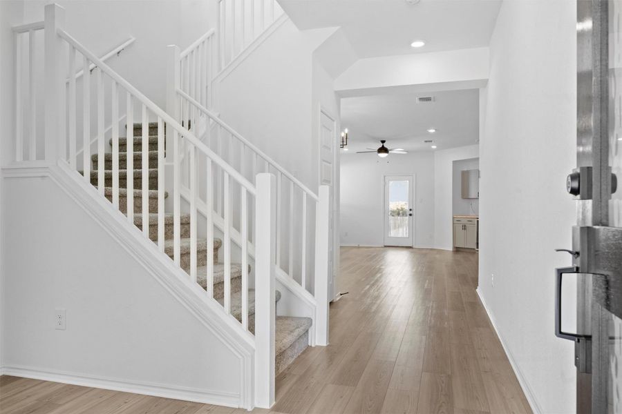 Foyer entrance with stairway, light wood-style floors, ceiling fan, and recessed lighting