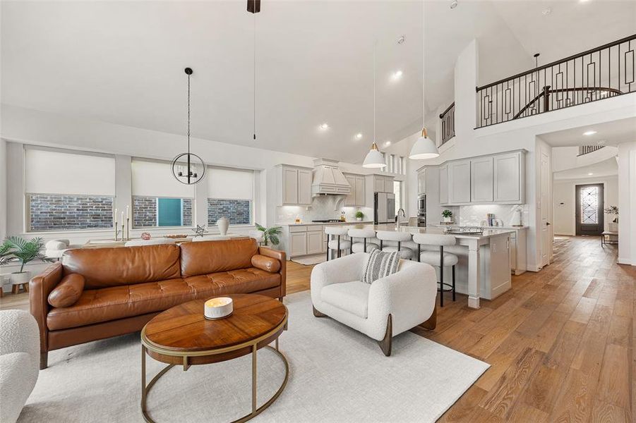 Living area with light wood-style floors and a towering ceiling