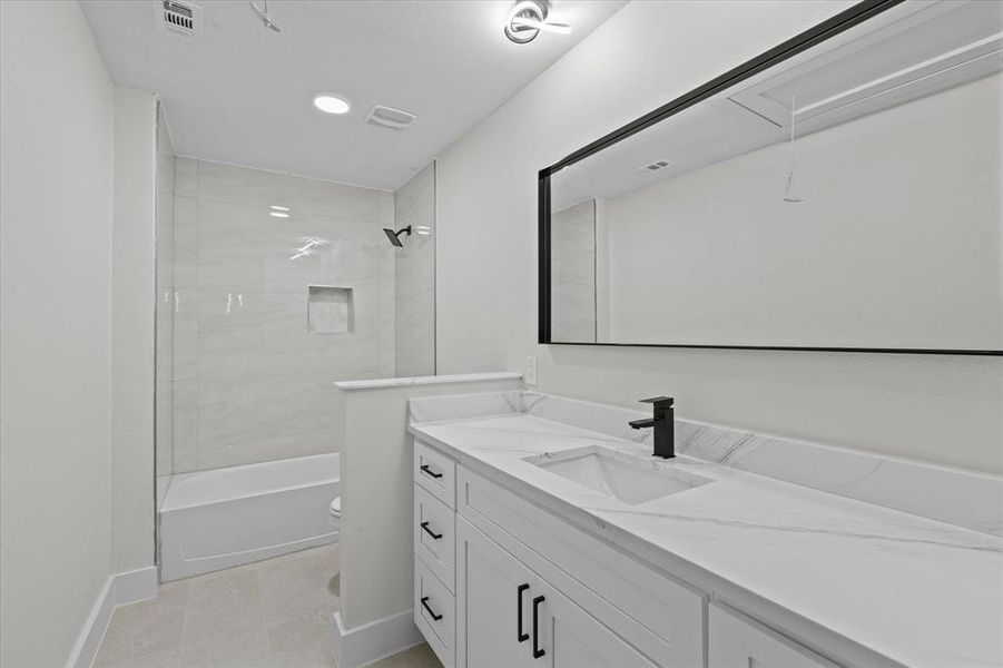Bathroom featuring vanity, shower / bathtub combination, and tile patterned floors