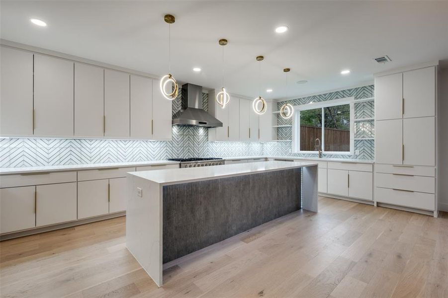 Kitchen with white cabinets, modern cabinets, hanging light fixtures, and recessed lighting
