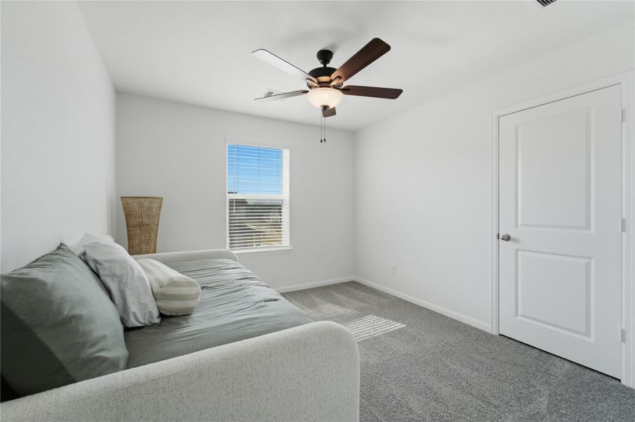 A well-lit bedroom features plush carpeting and a modern ceiling fan, offering a comfortable personal retreat. A well-lit bedroom features plush carpeting and a modern ceiling fan, offering a comfortable personal retreat.