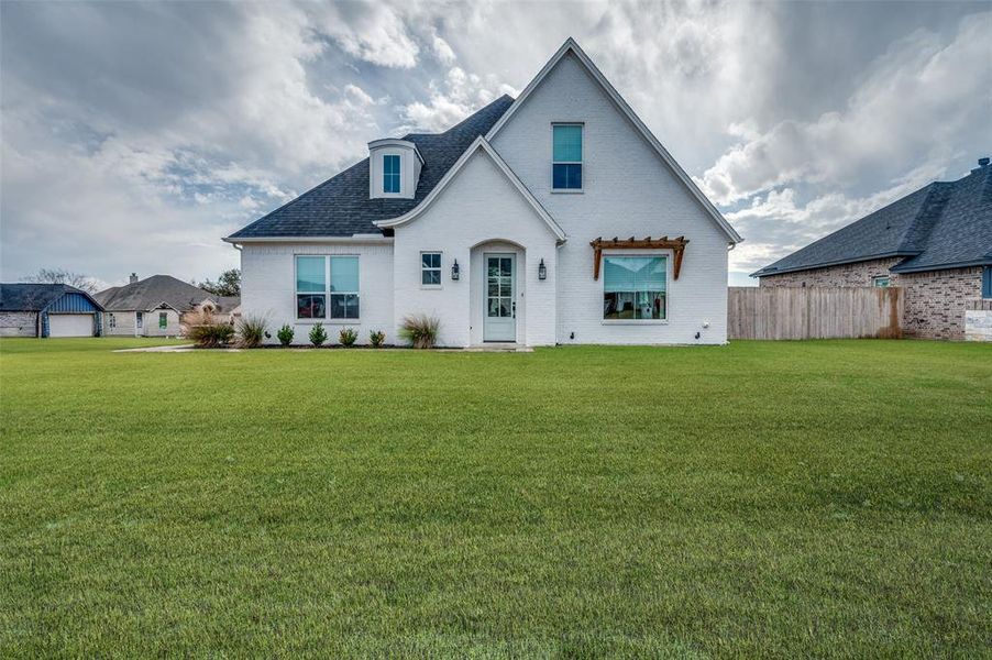 Rear view of property with a yard