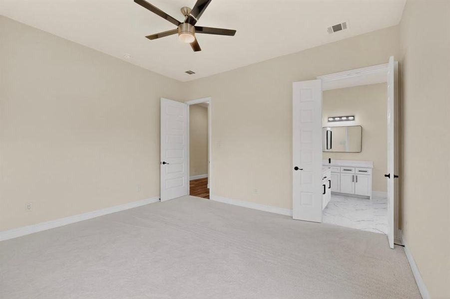 Neutral-toned room featuring a ceiling fan with integrated lighting, light carpet flooring, and white trim