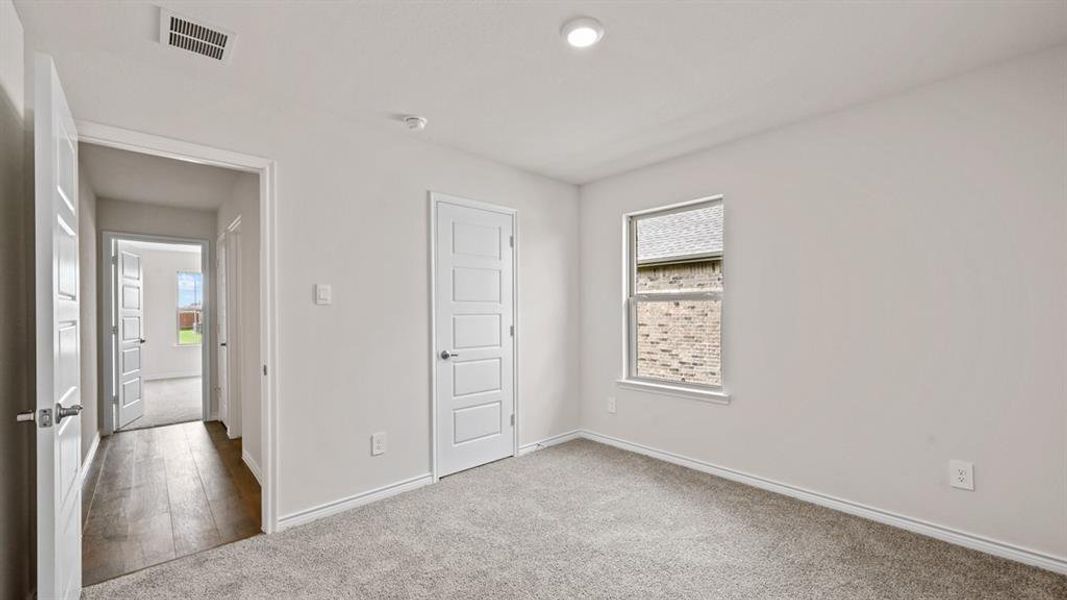 Carpeted room featuring a single window, recessed lighting, and a white paneled door Carpeted room featuring a single window, recessed lighting, and a white paneled door