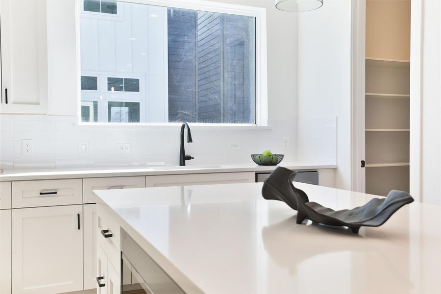 Take in the view through your picture window above your kitchen sink, complemented by 12"x3" glossy white subway picket tiles.