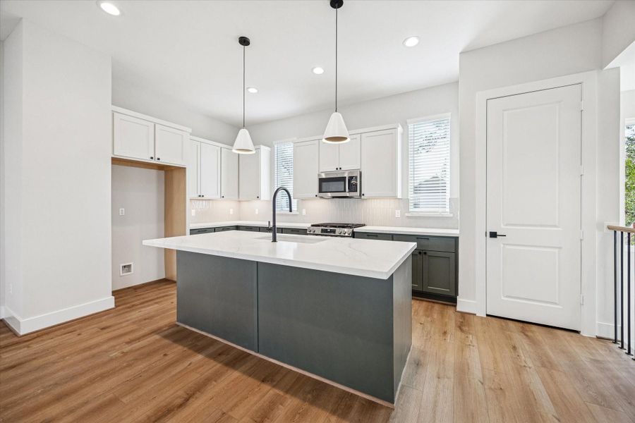 Anchored by two stylish pendants, the kitchen provides abundant counter space perfect for preparing and sharing your favorite meals.
