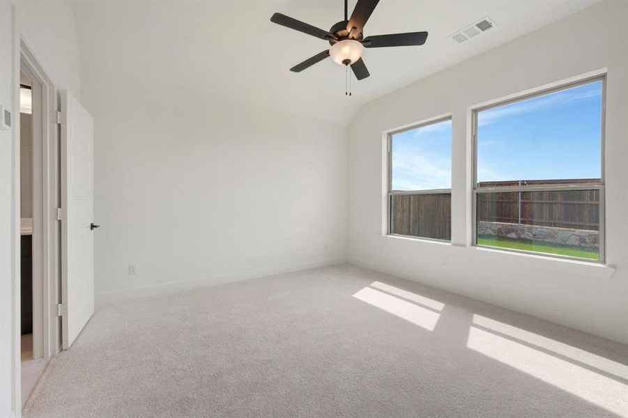 Spare room featuring light carpet, ceiling fan, and vaulted ceiling Spare room featuring light carpet, ceiling fan, and vaulted ceiling