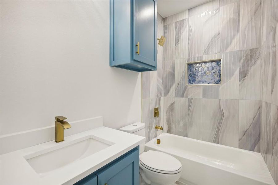 Full bathroom featuring vanity, toilet, and tiled shower / bath combo