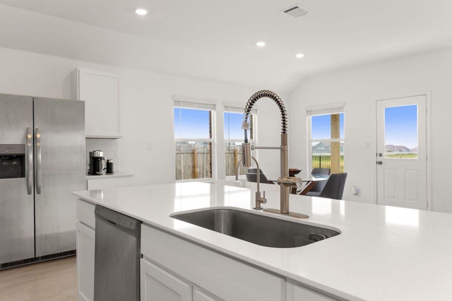 A well-appointed kitchen features a large island, contemporary appliances, and abundant natural light.