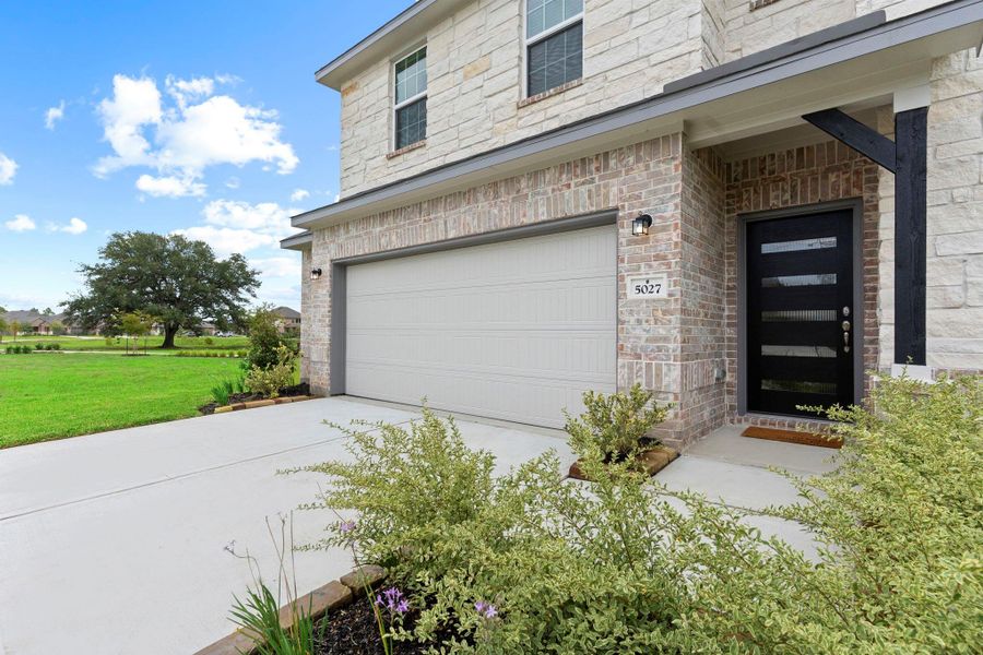 A cozy covered front porch and bold modern entry door create a stylish welcome. Surrounded by greenery, this inviting entrance reflects the tranquil charm of the Massey Oaks community and sets the tone for the upscale interior that follows. A cozy covered front porch and bold modern entry door create a stylish welcome. Surrounded by greenery, this inviting entrance reflects the tranquil charm of the Massey Oaks community and sets the tone for the upscale interior that follows.
