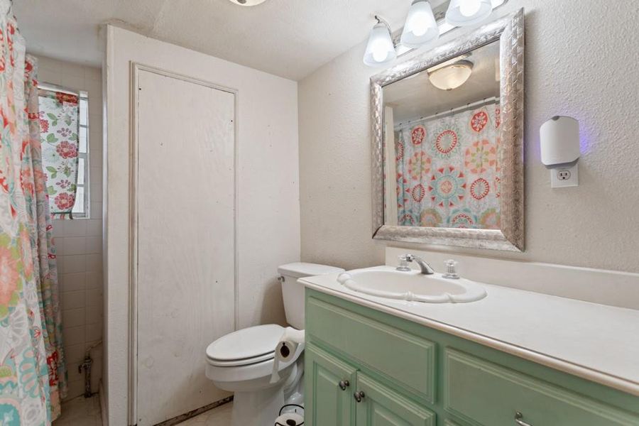 Bathroom featuring vanity, toilet, tile patterned flooring, and a shower with curtain