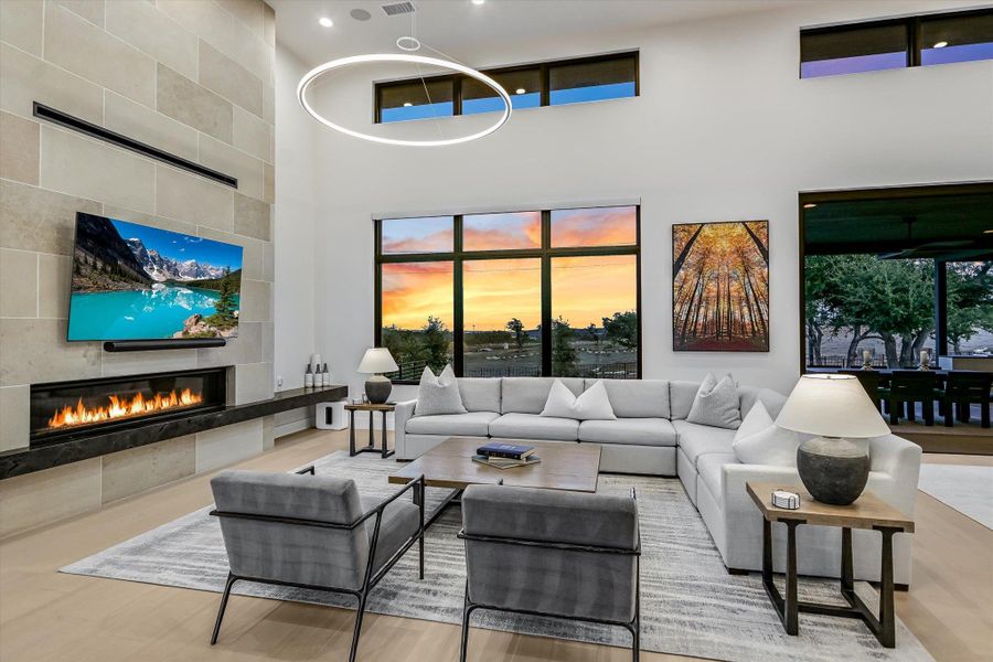 Living room featuring a tiled fireplace and a high ceiling Living room featuring a tiled fireplace and a high ceiling