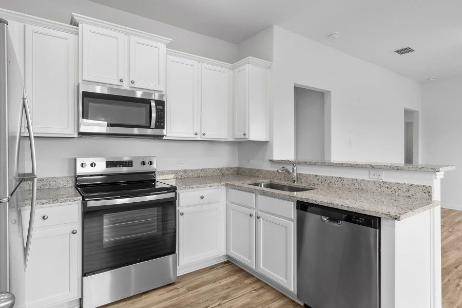 The kitchen of this plan comes completely chef ready. From the plentiful cabinet space and sprawling granite countertops, to the stainless steel Whirlpool® appliances, this room is sure to make a lasting impression. Additionally, you will love how roomy and open this space is!
