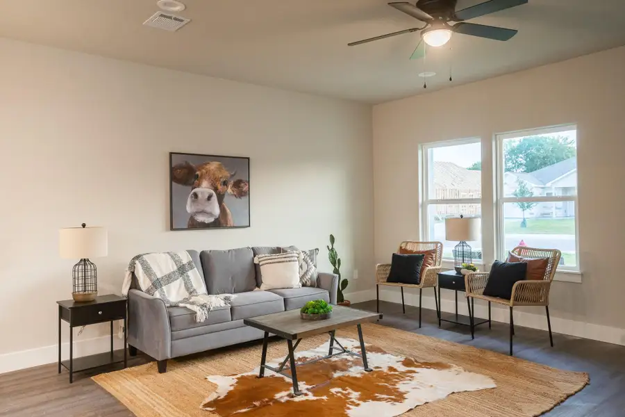 Living area featuring baseboards, wood finished floors, and ceiling fan Living area featuring baseboards, wood finished floors, and ceiling fan