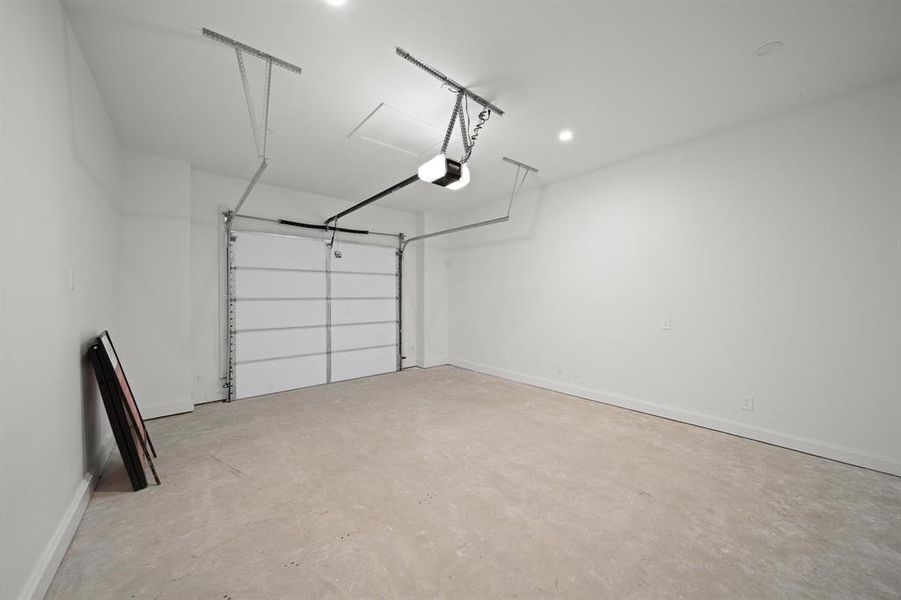 Garage featuring baseboards and a garage door opener