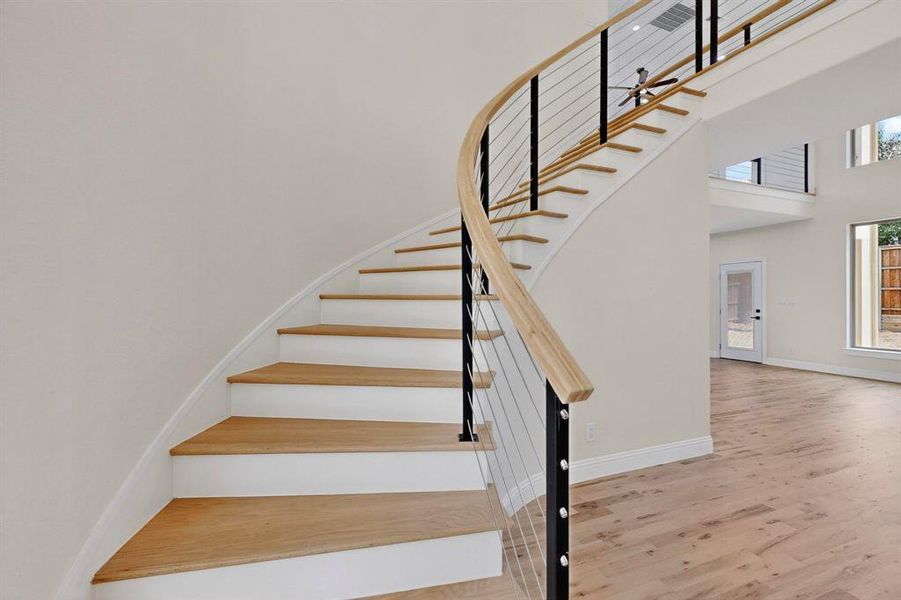 Stairway with wood finished floors and a high ceiling Stairway with wood finished floors and a high ceiling