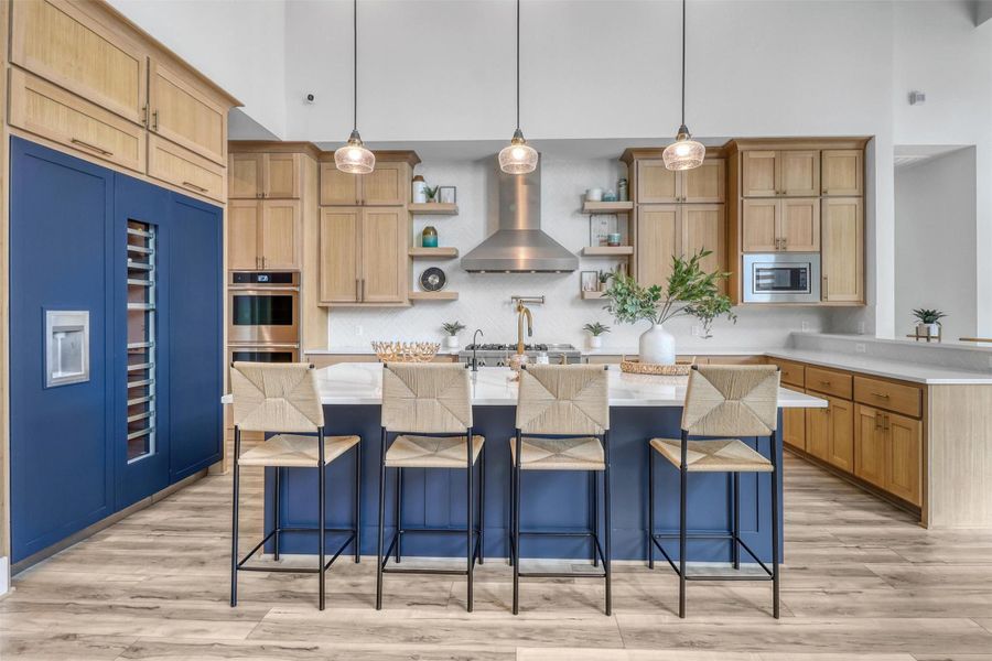 Wood cabinetry is accented with a beautiful blue island and matching built-in Thermador Refrigerator and Freezer with Wine Cooler.