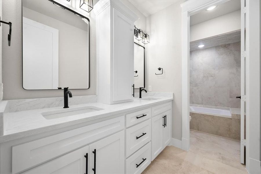 Bathroom with tile patterned flooring, vanity, and tiled shower / bath