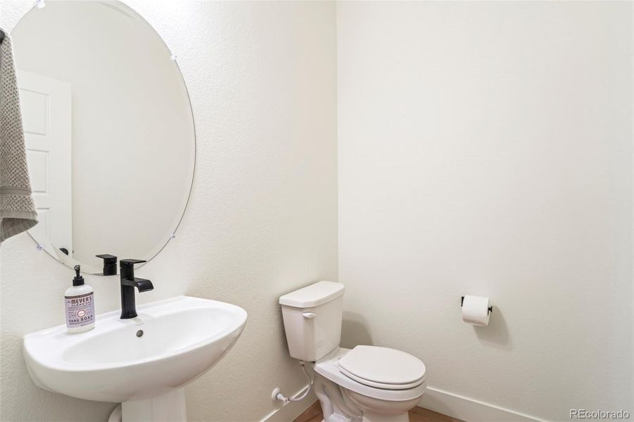 Main floor powder bathroom with clean, modern finishes for everyday convenience in this move-in ready Morrison Colorado home