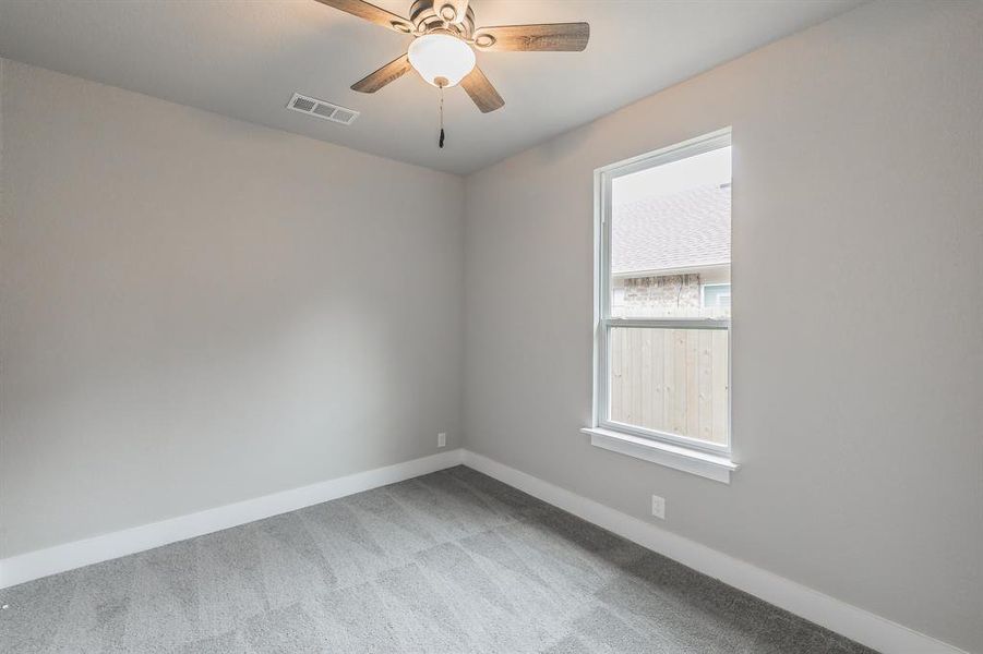 Carpeted empty room with ceiling fan