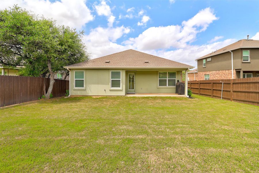 Expansive green lawn with a privacy fence