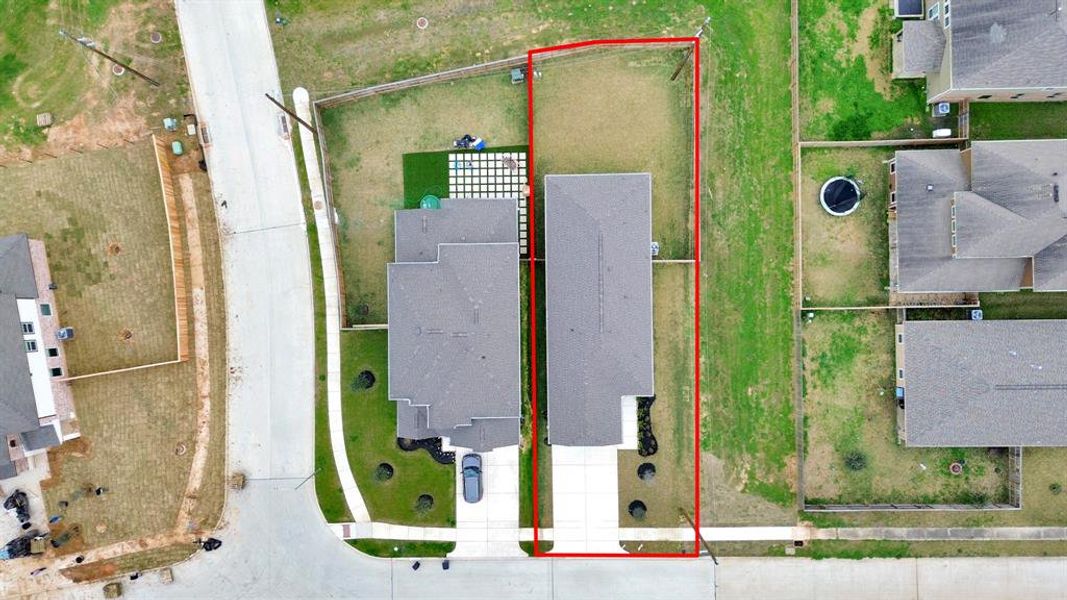 An aerial view of a spacious subdivision lot, highlighting a well-maintained yard and a fully fenced perimeter, offering both privacy and expansive outdoor space.