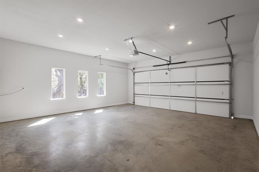 Garage with recessed lighting, baseboards, and a garage door opener
