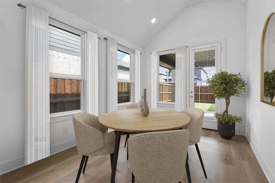 Dining room featuring light wood finished floors, plenty of natural light, lofted ceiling, and recessed lighting Dining room featuring light wood finished floors, plenty of natural light, lofted ceiling, and recessed lighting
