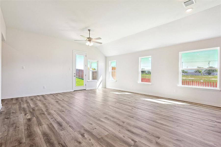 Unfurnished room featuring light wood-type flooring, lofted ceiling, and ceiling fan