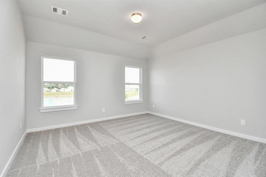 Generously sized secondary bedrooms featuring spacious closets, soft and inviting carpeting underfoot, large windows allowing plenty of natural light. Sample photo of completed home with similar floor plan.