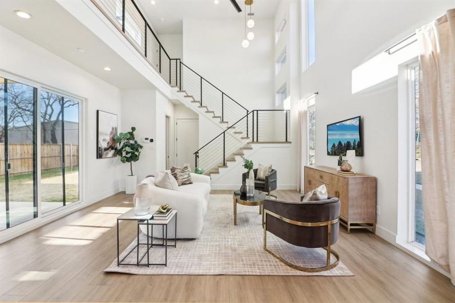 Living room featuring light hardwood / wood-style floors and a towering ceiling