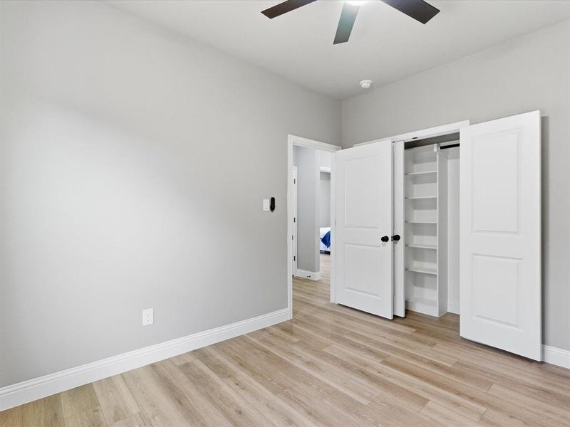 Unfurnished bedroom with light wood-type flooring, ceiling fan, and a closet Unfurnished bedroom with light wood-type flooring, ceiling fan, and a closet