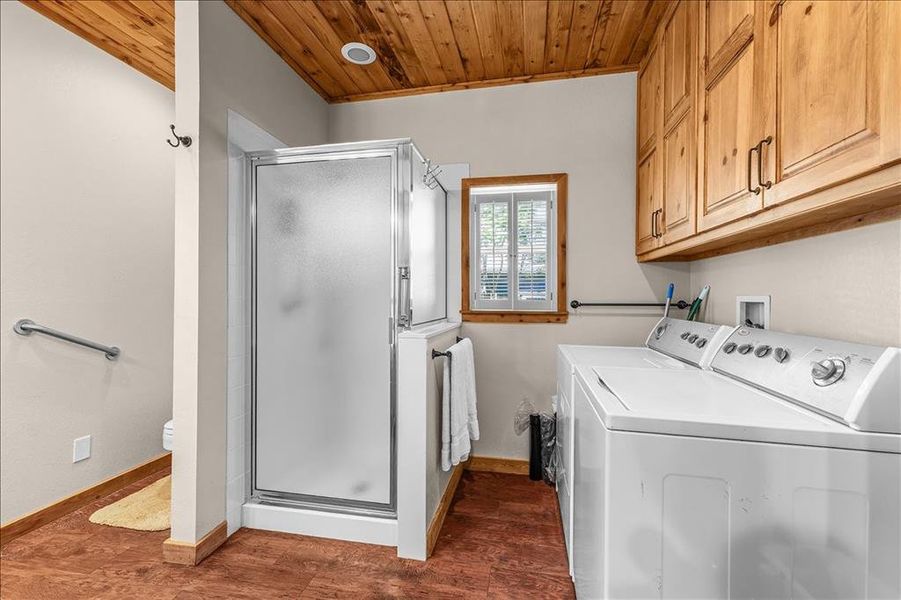 Laundry area featuring wooden ceiling, dark wood finished floors, and washing machine and clothes dryer