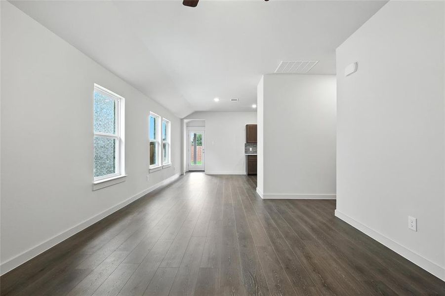 Unfurnished living room with a ceiling fan, lofted ceiling, dark wood-style flooring, and recessed lighting Unfurnished living room with a ceiling fan, lofted ceiling, dark wood-style flooring, and recessed lighting