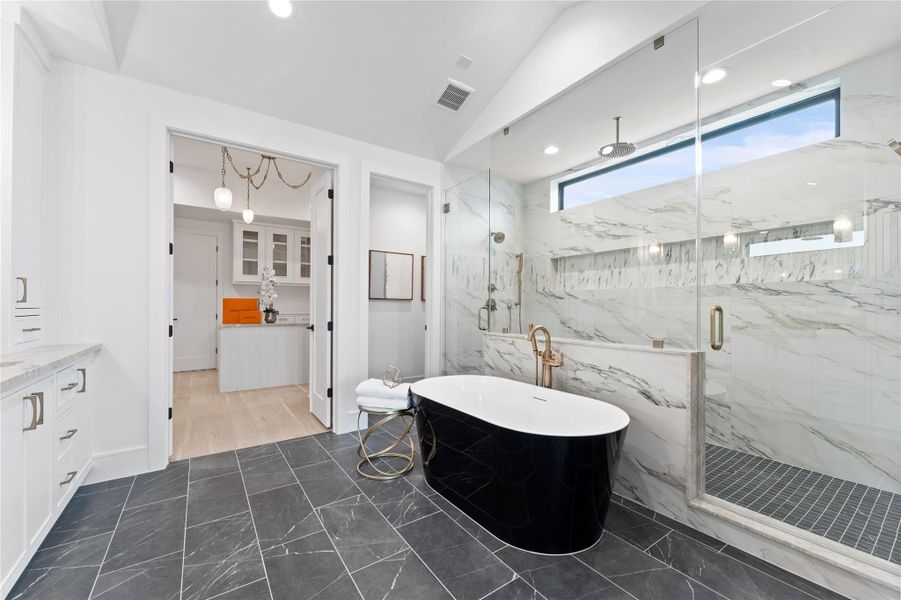 Spa-inspired primary bath with freestanding soaking tub and faucet.
