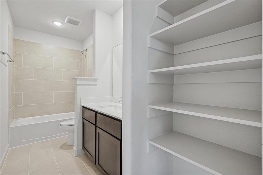 Full bathroom featuring vanity, shower / tub combination, light tile patterned flooring, and a closet Full bathroom featuring vanity, shower / tub combination, light tile patterned flooring, and a closet