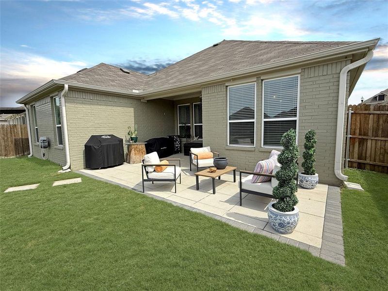 Back of property featuring a patio, brick siding, roof with shingles, and an outdoor hangout area Back of property featuring a patio, brick siding, roof with shingles, and an outdoor hangout area