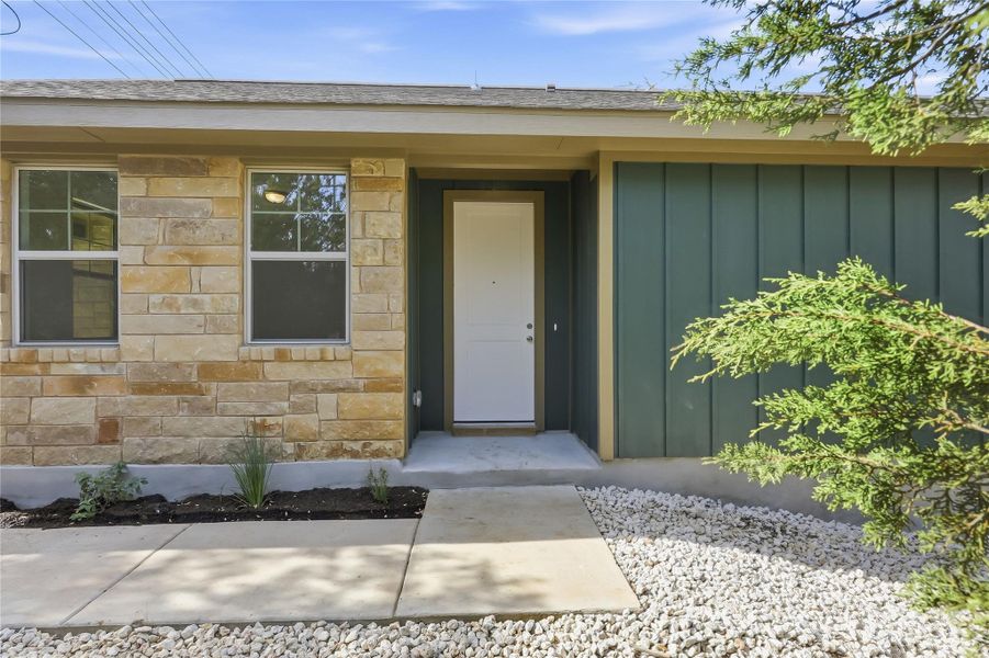 Property entrance with board and batten siding and stone siding