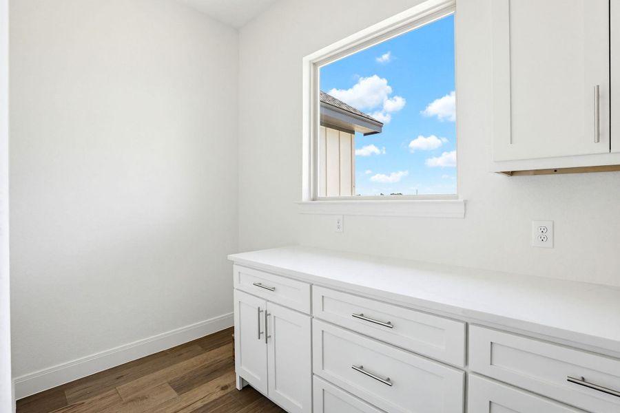 A well-lit area features ample cabinetry and countertop space beneath a broad window.
