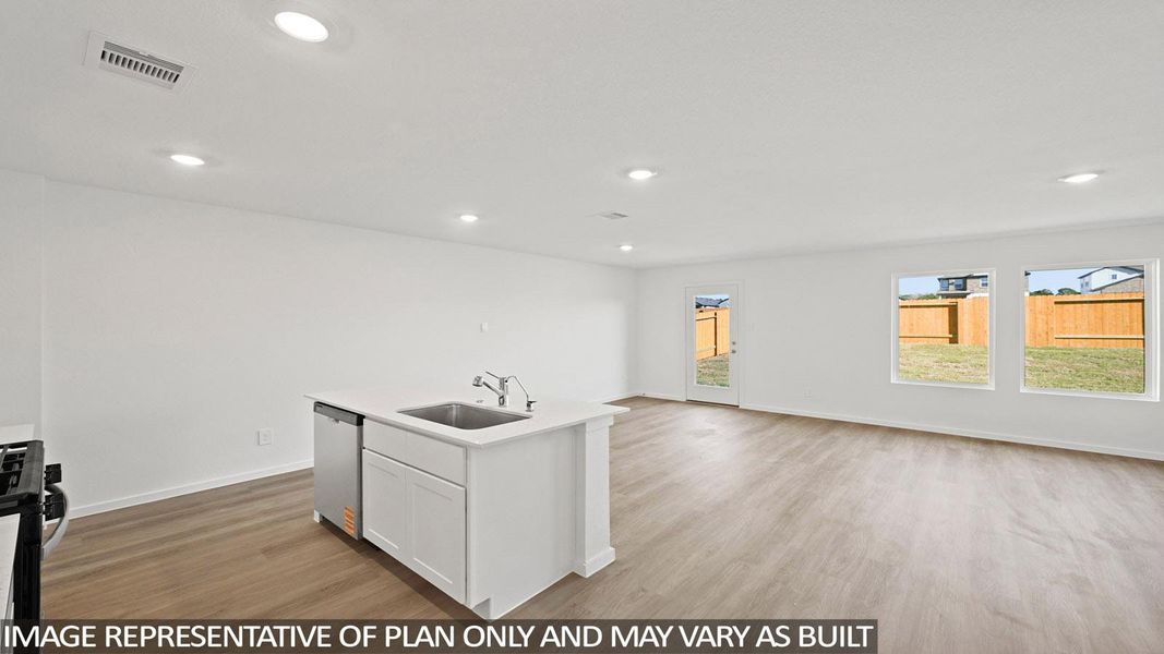 Kitchen with light wood finished floors, open floor plan, white cabinetry, an island with sink, and gas stove