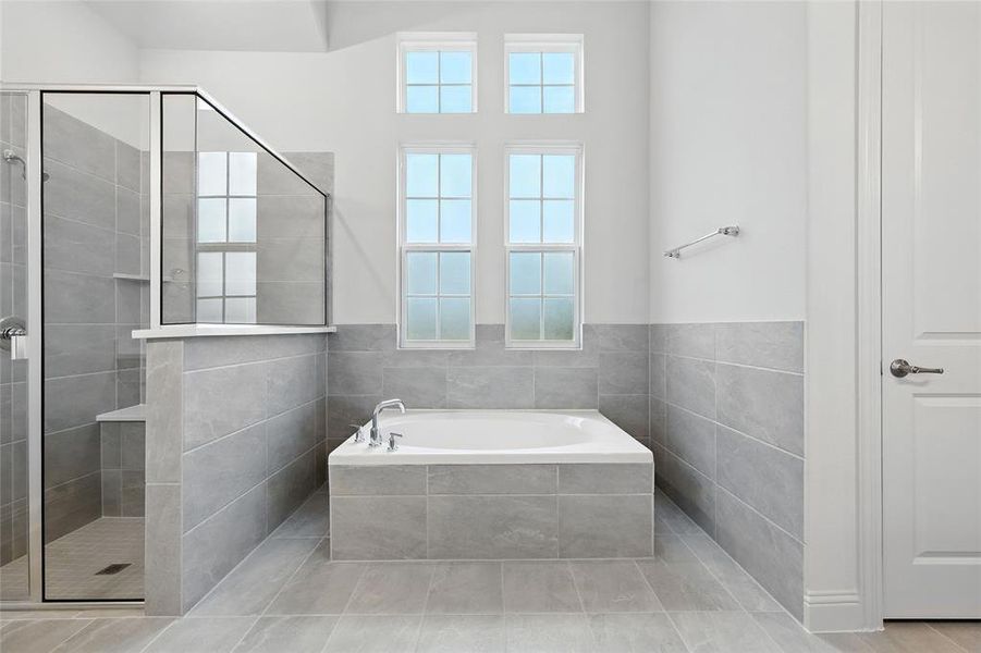 Full bathroom featuring a bath, a stall shower, and light tile patterned floors