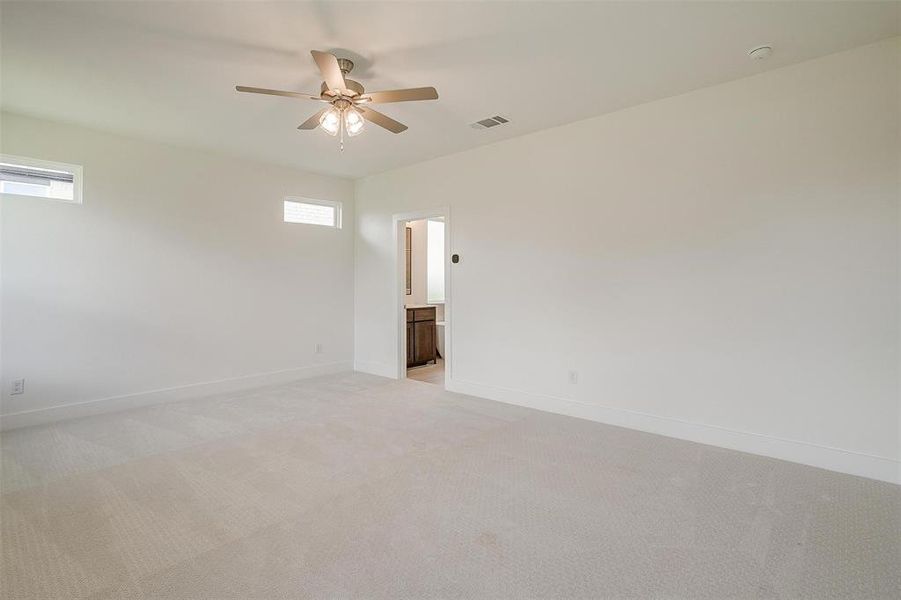 Spare room with ceiling fan and carpet flooring