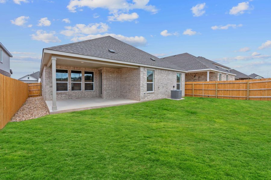 Rear view of house featuring a fenced backyard, brick siding, a patio area, and roof with shingles Rear view of house featuring a fenced backyard, brick siding, a patio area, and roof with shingles