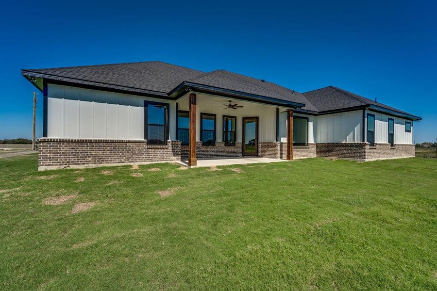 Back of property with a lawn, ceiling fan, and a patio area