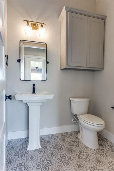 Half bathroom with baseboards and light tile patterned floors Half bathroom with baseboards and light tile patterned floors