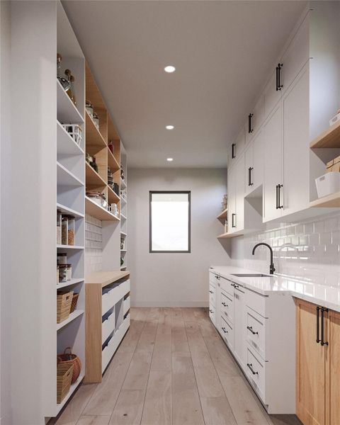 Hidden but gorgeous!  This scullery showcases a lot of countertop and cabinetry space.  A Calacatta quartz with a refined backsplash in Pearl Opal and a lot of natural light, make this preparation, cleaning and storage make this practical area a true delight. Additional shelving on both sides of the butcher block serve to display ornaments, cooking books, small appliances, vases or any other utensils or decor. This is a render.