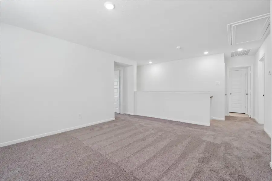 Another perspective of the Loft, showcasing the staircase and hallway leading to the secondary bedrooms. Another perspective of the Loft, showcasing the staircase and hallway leading to the secondary bedrooms.