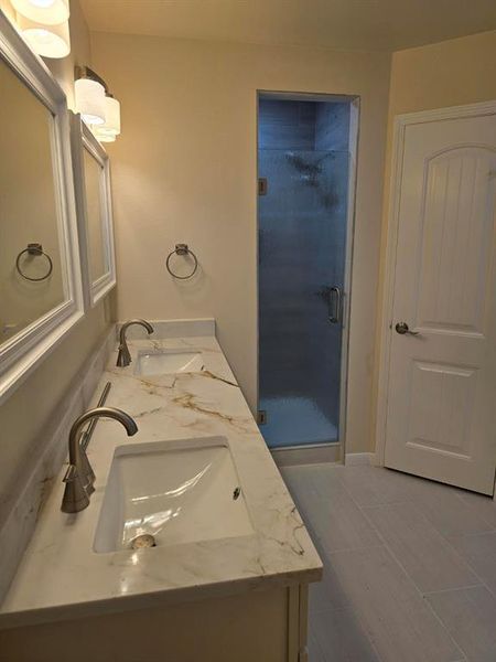 Bathroom featuring double vanity and a stall shower Bathroom featuring double vanity and a stall shower