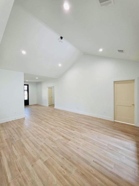 Spare room featuring light wood-style flooring, lofted ceiling, and recessed lighting